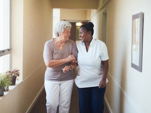 Older adult and family member talking with a senior living staff member in a community common area